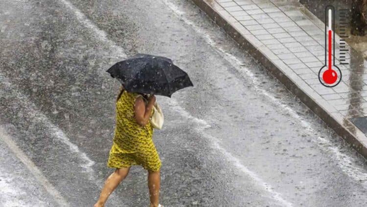 Mujer con paraguas bajo tormenta en Madrid tras ola de calor de 41 grados.