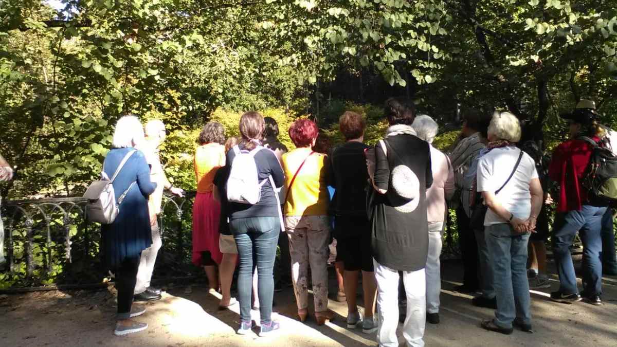 Grupo de personas en ruta guiada gratuita del programa Entreparques por parques de Madrid en verano.