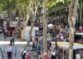 Mercadillo en Madrid con puestos de ropa y artesanía al aire libre.
