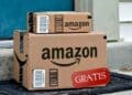 Paquetes de Amazon en una puerta con cartel gratis por envío duplicado de monitor OLED.