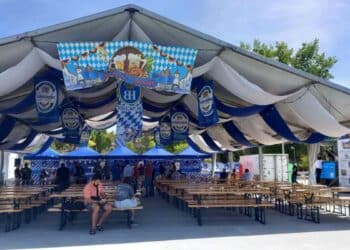 Carpa bávara de la Oktoberfest en Vallecas Madrid con mesas de madera y decoración alemana.