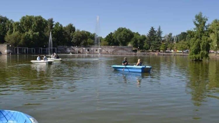 Personas navegando en barca por la laguna del Parque de la Laguna Carrizal en Collado Villalba, Madrid.