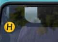 Pegatina H de la DGT en parabrisas de coche histórico.