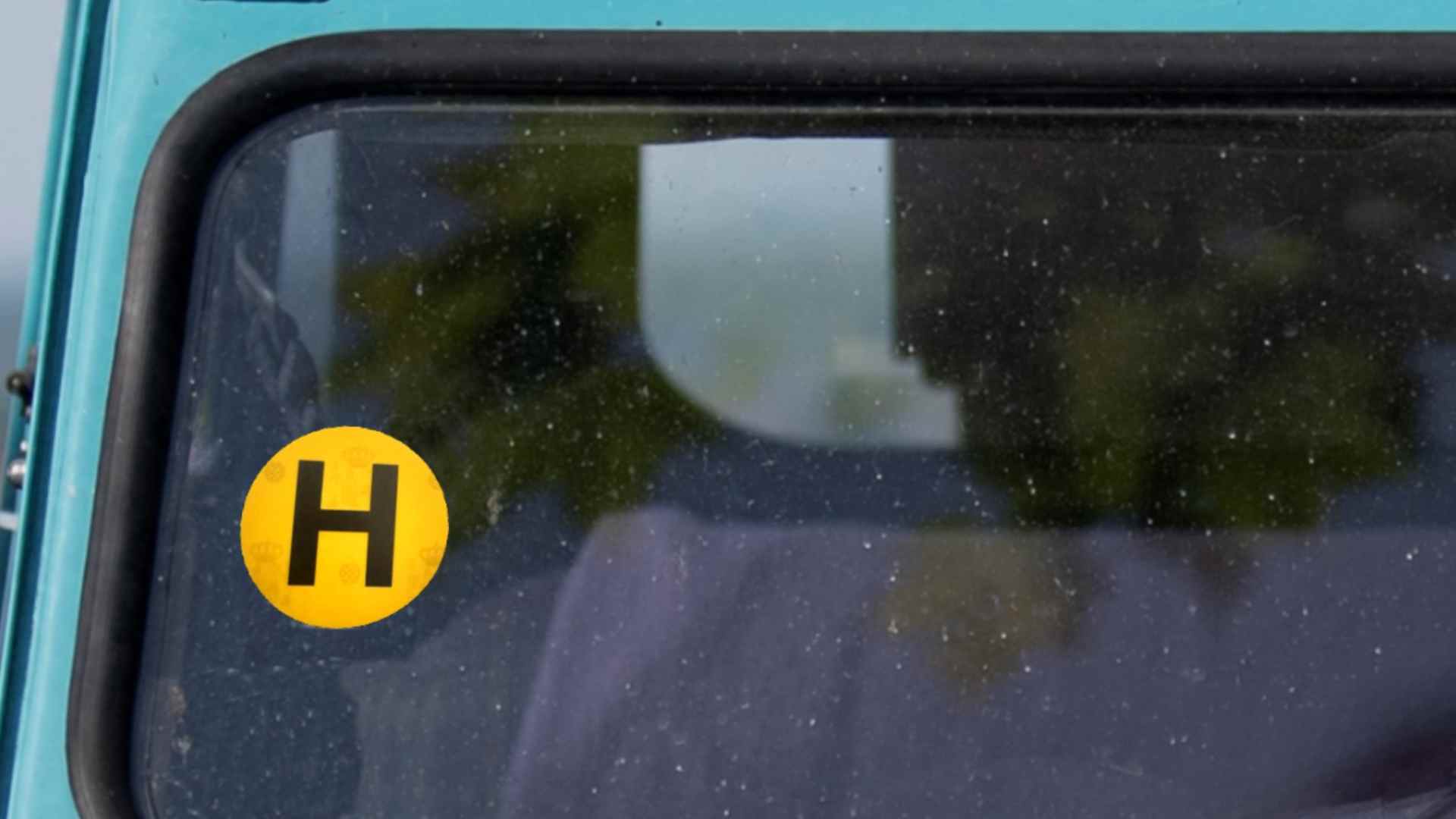 Pegatina H de la DGT en parabrisas de coche histórico.