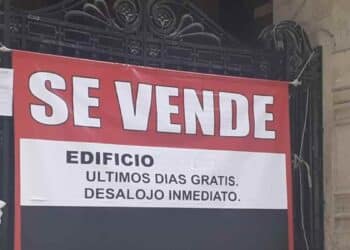 Cartel de se vende edificio con aviso de desalojo inmediato en plena crisis de vivienda.
