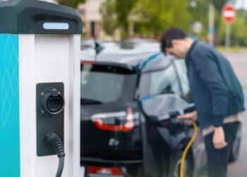 Coche eléctrico cargando en punto de recarga reservado según normativa de la DGT.