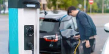Coche eléctrico cargando en punto de recarga reservado según normativa de la DGT.