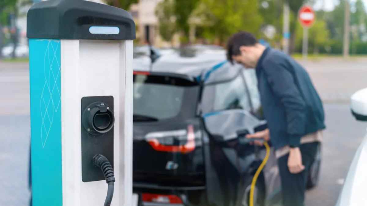 Coche eléctrico cargando en punto de recarga reservado según normativa de la DGT.