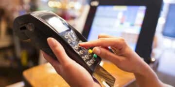 Persona introduciendo PIN en datáfono al pagar con tarjeta.
