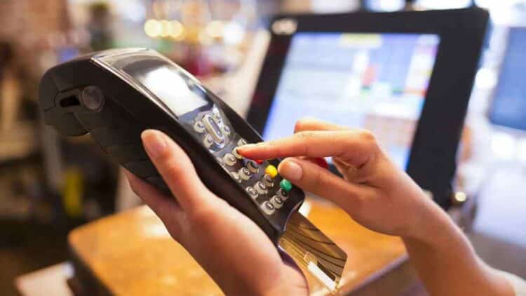 Persona introduciendo PIN en datáfono al pagar con tarjeta.