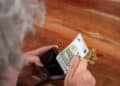 Persona mayor contando dinero de la pensión de viudedad.
