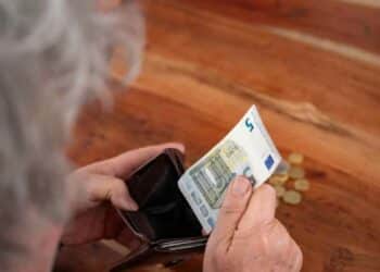 Persona mayor contando dinero de la pensión de viudedad.
