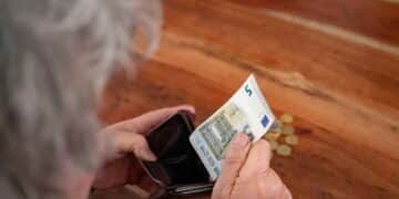Persona mayor contando dinero de la pensión de viudedad.