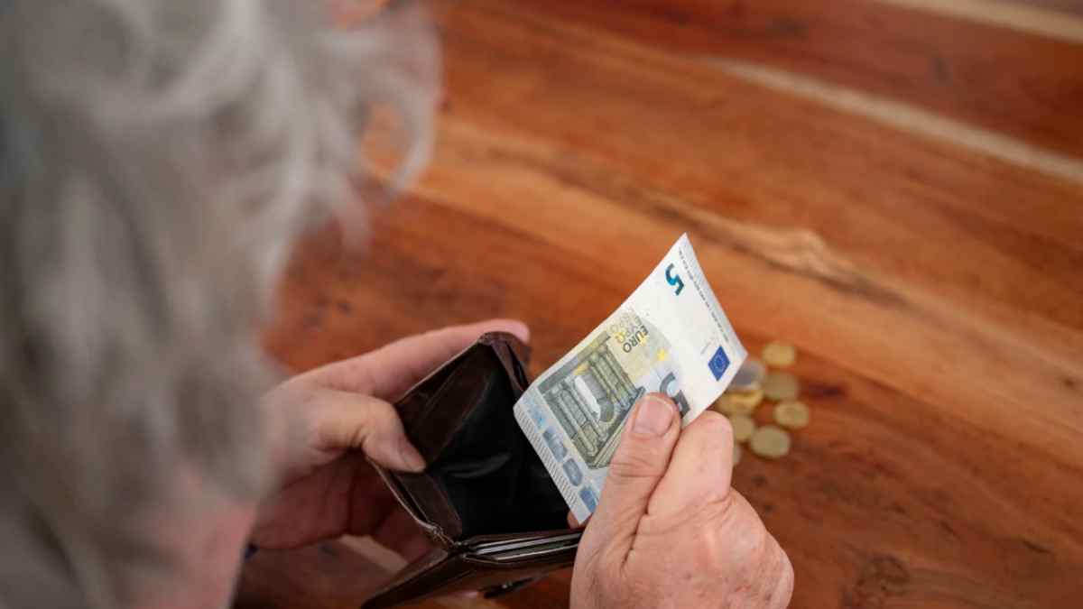 Persona mayor contando dinero de la pensión de viudedad.