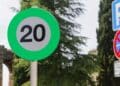 Señal de tráfico verde de velocidad recomendada 20 km/h en carretera.