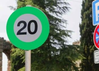Señal de tráfico verde de velocidad recomendada 20 km/h en carretera.