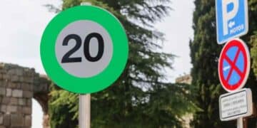 Señal de tráfico verde de velocidad recomendada 20 km/h en carretera.