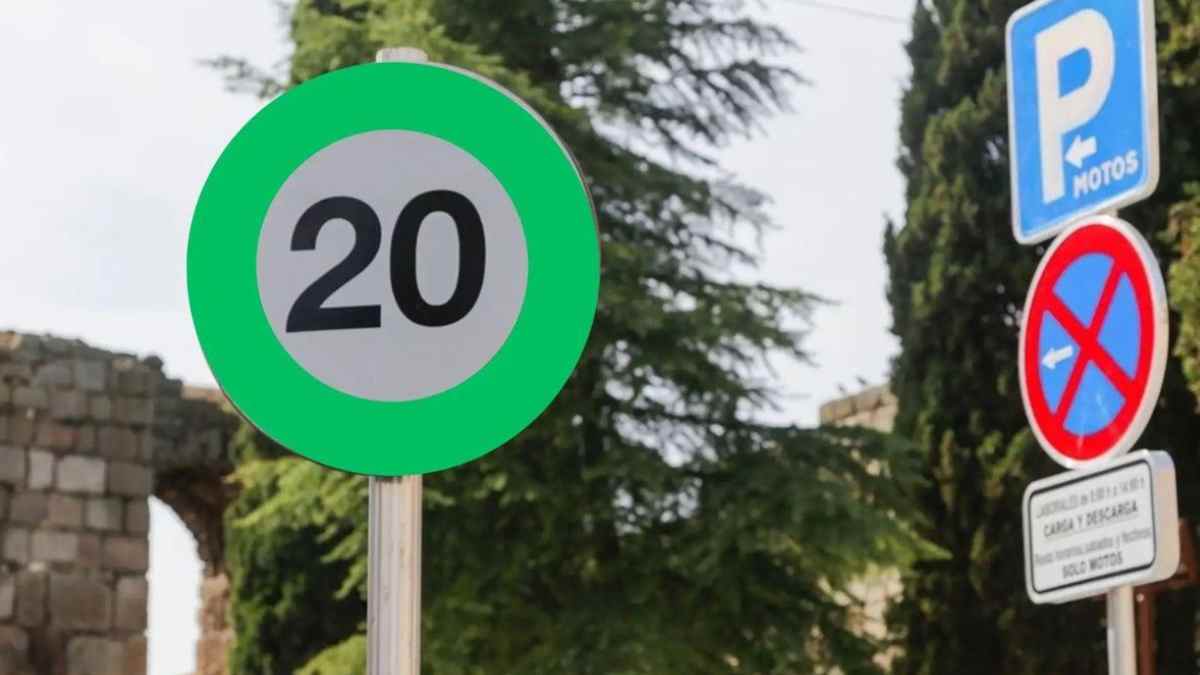 Señal de tráfico verde de velocidad recomendada 20 km/h en carretera.