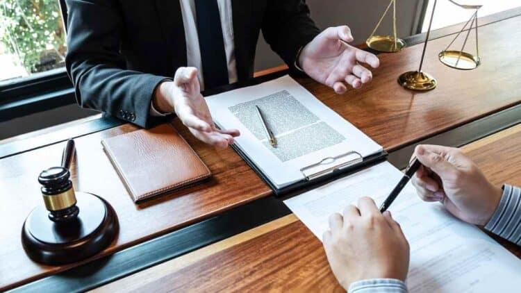 Abogado y cliente revisando testamento para desheredar a un hijo por abandono emocional.