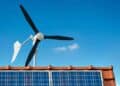 Aerogenerador doméstico SkyWind junto a placas solares en tejado.