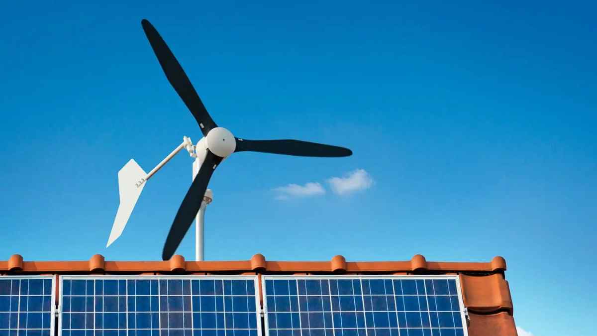 Aerogenerador doméstico SkyWind junto a placas solares en tejado.