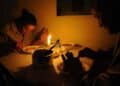 Personas cenando con velas durante apagón por colapso de redes eléctricas en España.