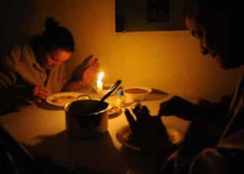 Personas cenando con velas durante apagón por colapso de redes eléctricas en España.