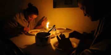 Personas cenando con velas durante apagón por colapso de redes eléctricas en España.