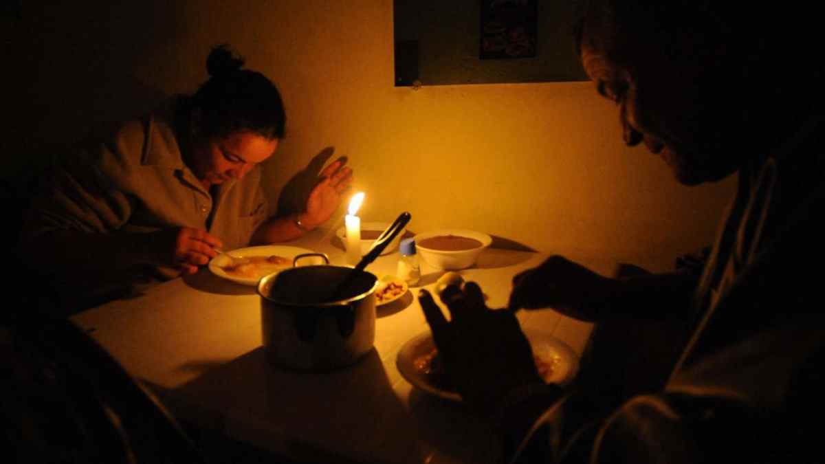 Personas cenando con velas durante apagón por colapso de redes eléctricas en España.