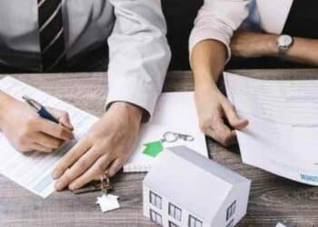 Personas firmando documentos para ayudas a hipotecas en 2025.