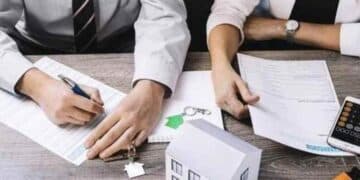 Personas firmando documentos para ayudas a hipotecas en 2025.