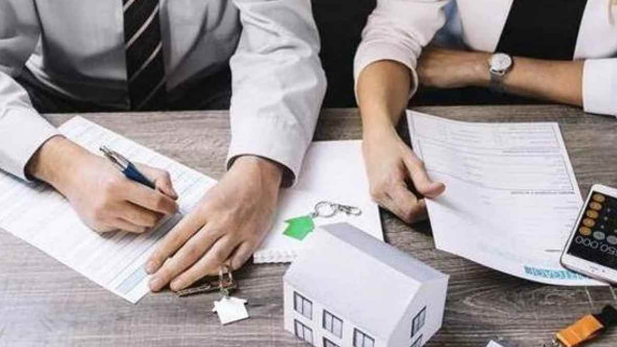 Personas firmando documentos para ayudas a hipotecas en 2025.