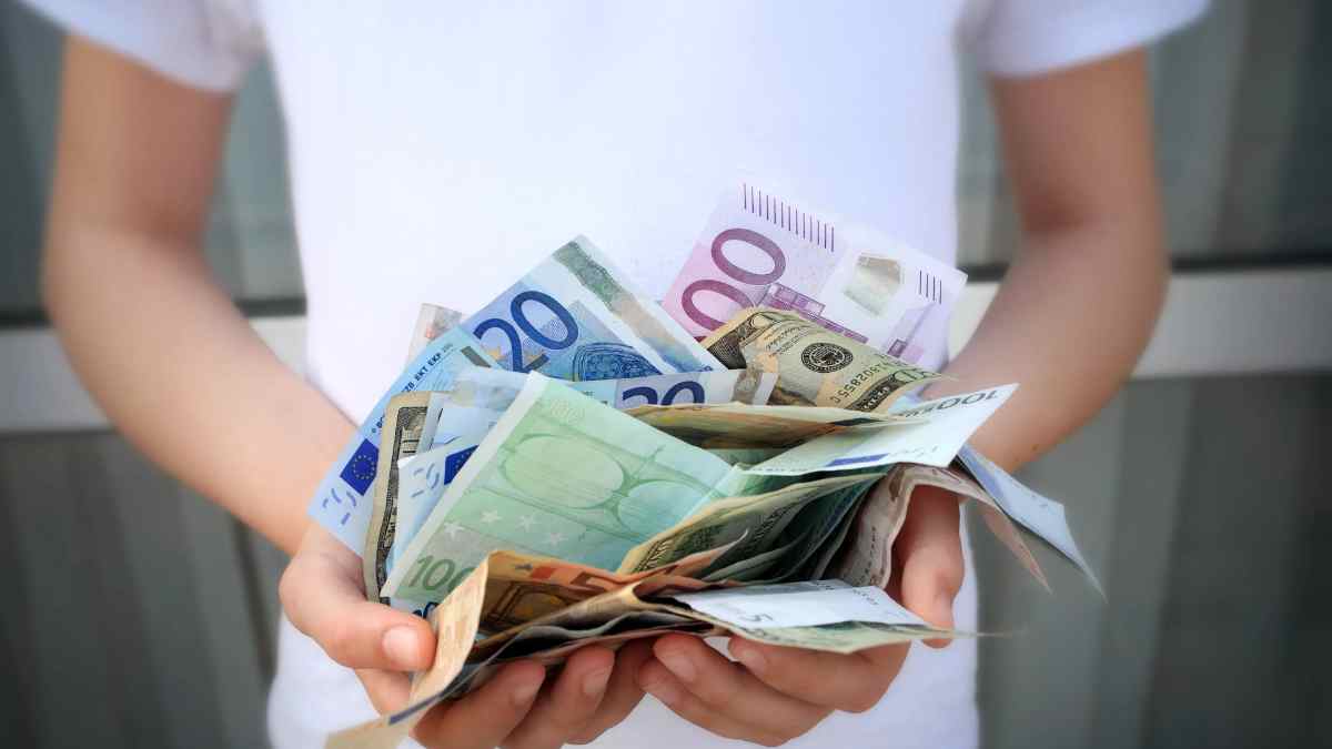 Persona con billetes de euros representando ayudas del SEPE y nuevo tope de ingresos 2025.