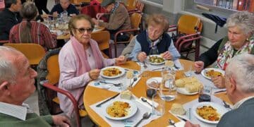 Personas mayores en un comedor municipal de Madrid compartiendo comida.