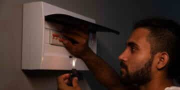 Hombre revisando cuadro eléctrico durante un corte de luz en Madrid por mantenimiento de Iberdrola.