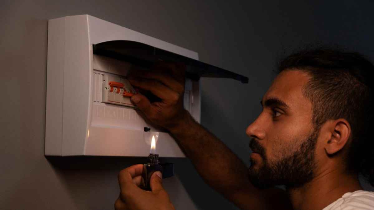 Hombre revisando cuadro eléctrico durante un corte de luz en Madrid por mantenimiento de Iberdrola.