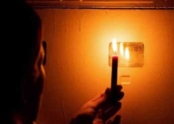Apagón en Madrid por cortes de luz con una persona usando una vela durante mantenimiento eléctrico en septiembre 2025.