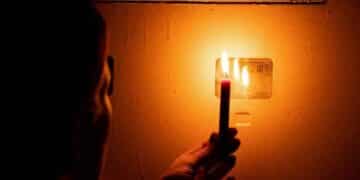 Apagón en Madrid por cortes de luz con una persona usando una vela durante mantenimiento eléctrico en septiembre 2025.
