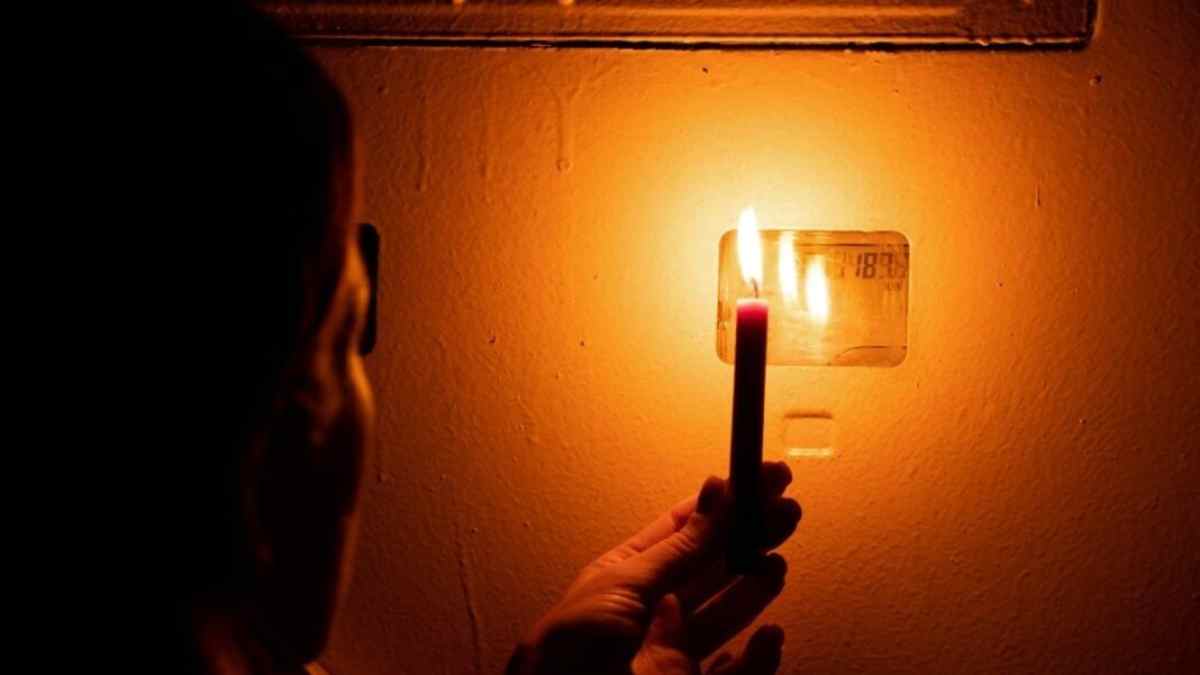 Apagón en Madrid por cortes de luz con una persona usando una vela durante mantenimiento eléctrico en septiembre 2025.