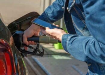 Conductor usando el móvil mientras reposta gasolina en gasolinera multado por la DGT.