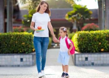 Madre recoge a su hija del colegio tras adaptar horario laboral según Estatuto de los Trabajadores.