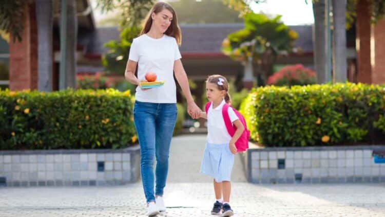 Madre recoge a su hija del colegio tras adaptar horario laboral según Estatuto de los Trabajadores.