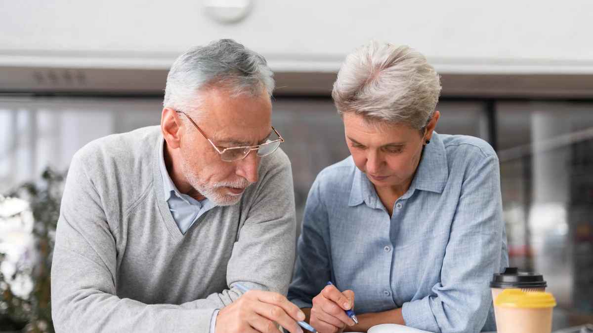Pareja de jubilados revisando papeles para devolución del IRPF de mutualistas.