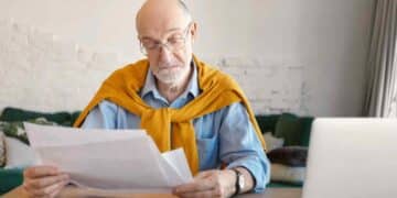 Hombre mayor revisando papeles sobre jubilación anticipada de mutualistas anteriores a 1967.