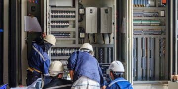 Trabajadores del sector eléctrico en Madrid revisando instalaciones industriales.