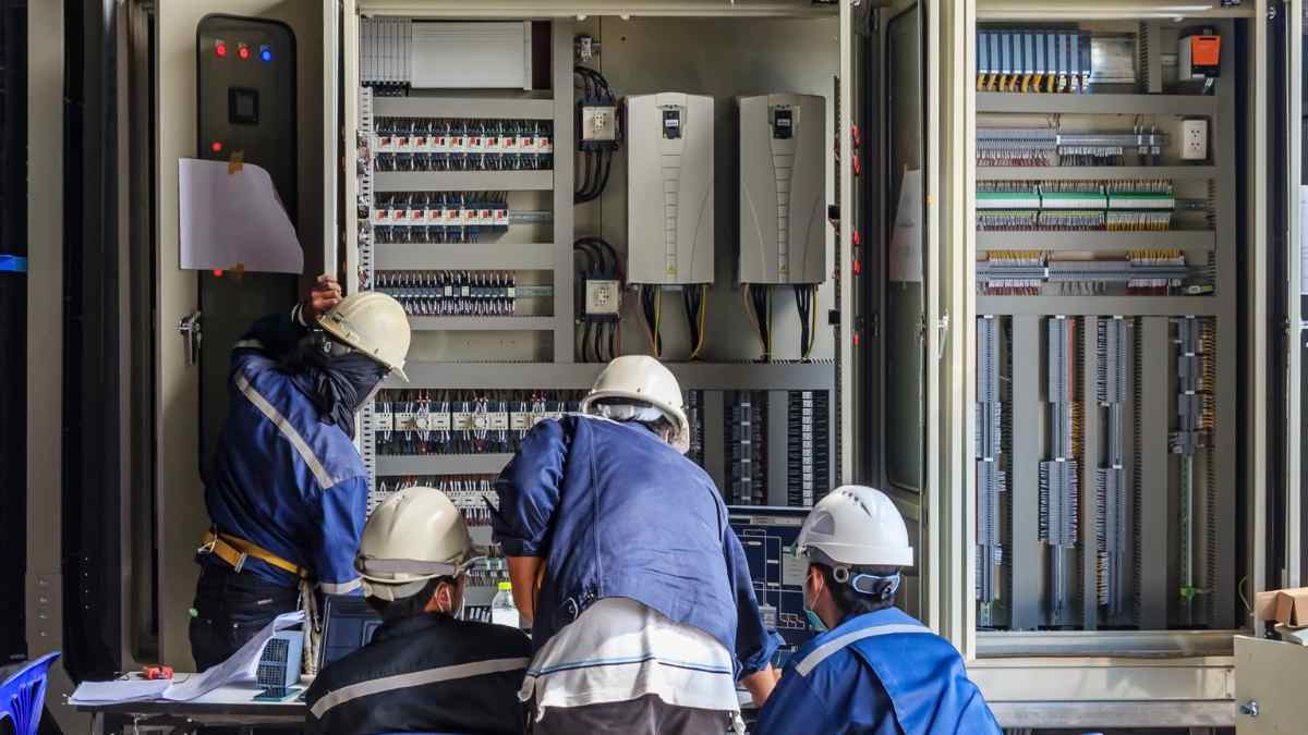Trabajadores del sector eléctrico en Madrid revisando instalaciones industriales.