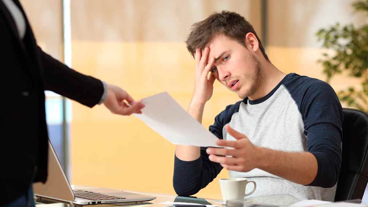 Trabajador preocupado tras recibir carta de despido en período de prueba.
