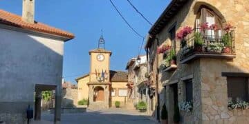 Plaza del Ayuntamiento de Arbancón en Guadalajara con casas de piedra y viviendas tradicionales.