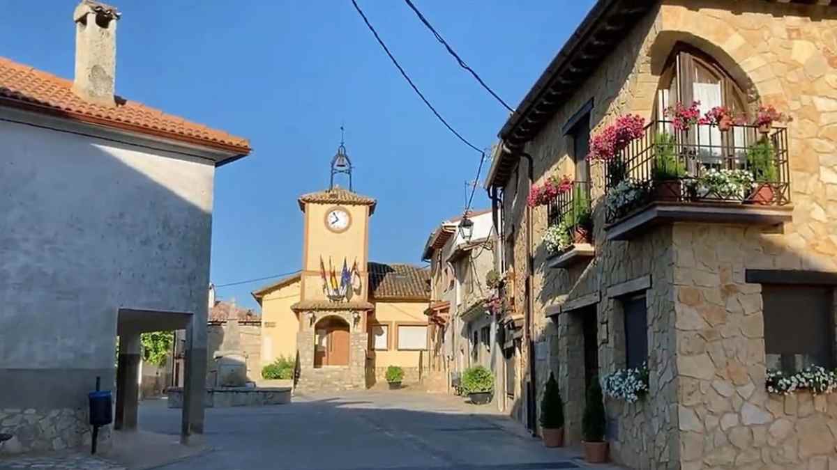 Plaza del Ayuntamiento de Arbancón en Guadalajara con casas de piedra y viviendas tradicionales.