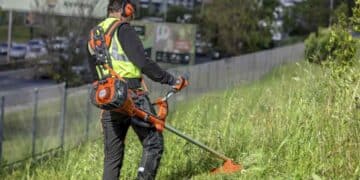 Jardinero trabajando con desbrozadora en Madrid durante labores de mantenimiento de zonas verdes.